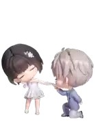 a boy is kneeling down and holding the hand of a girl