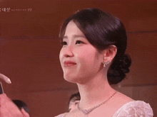 a woman wearing a white dress and a necklace with gucci written on the bottom