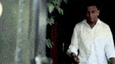 a man in a white shirt is standing in a dark room