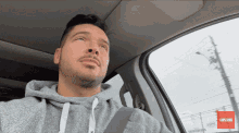 a man in a car with a subscribe button on the bottom