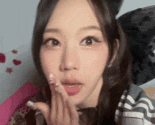 a close up of a woman 's face with her hand on her face .