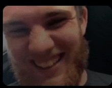 a man with a beard and glasses is smiling