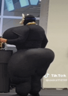 a woman in a black suit has a very large butt .