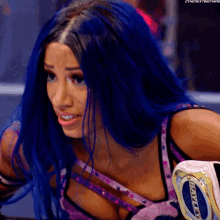 a woman with blue hair is wearing a purple top with the number 0 on it