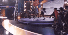 a group of people are dancing on a stage with a 106 and park sign behind them