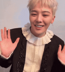 a man wearing a black jacket and a white shirt is smiling
