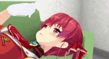 a girl with red hair is laying on a green couch with a white glove on her hand