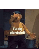 a cartoon character is standing in front of a trash can with the words `` tu się pierdolnij '' written on it .