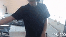 a man in a black t-shirt is standing in a room .