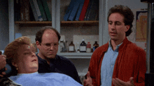three men are standing around a woman in a dental chair