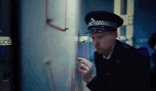 a police officer is smoking a cigarette in a dark room .