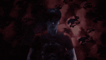 a man in a red shirt is standing in front of a wall with horses and clouds