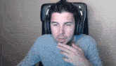 a man is wearing headphones and sitting in a chair .