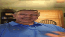 a man wearing a blue under armour shirt smiles for the camera