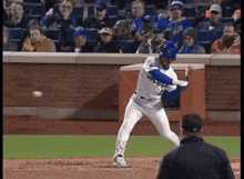 a mets baseball player swings his bat at a ball