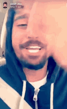 a man with a beard is wearing a black and white striped sweatshirt