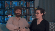 a man with a beard and glasses stands next to a woman with glasses and a beard