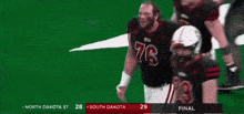 a football player with the number 76 on his jersey stands on the field