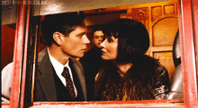 a man and a woman are looking at each other through a window with cherry-n-wonderland written on the wall behind them