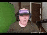 a man wearing headphones and a hat is making a funny face while playing a video game .