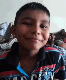 a young boy wearing a shirt with the number 92 on it smiles