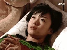 a woman laying on a bed with a sbs logo on the corner