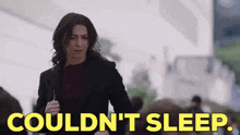 a woman is walking down a street with the words `` couldn 't sleep '' written on the screen .