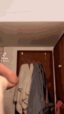 a person is standing in front of a closet with towels hanging on hooks