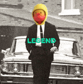 a man in a suit and tie with a rubber duck on his head is standing in front of a car that says legend on it
