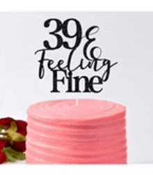 a pink cake with a cake topper that says `` 39 & feeling fine ''