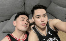 two men are posing for a picture and one of them is wearing a jersey that says ' nuggets ' on it