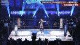 a woman is standing in a wrestling ring on a stage .
