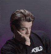 a young man wearing a black shirt that says world