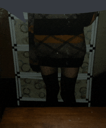 a person wearing a plaid sweater and black thigh high stockings