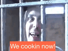 a man behind bars with the words " we cookin now " on the bottom
