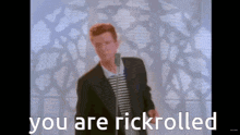 a man singing into a microphone with the words " you are rickrolled " above him