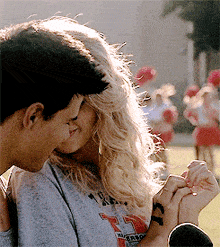 a man and a woman are kissing and the woman is wearing a t-shirt that says 7