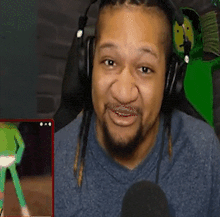 a man with dreadlocks is wearing headphones and making a funny face .