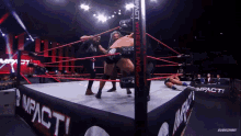 two men are wrestling in a ring that says impact