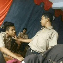 two men are talking to each other in a dark room