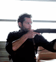 a man pointing a shotgun with his finger