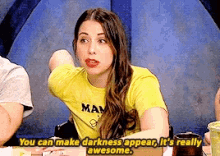 a woman wearing a yellow shirt that says man on it