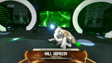 a wrestler named will osprey is laying on the ground on a stage