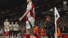 a soccer player wearing a number 11 jersey is walking on the field