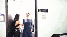 a woman in a blue dress is standing in front of a sign that says maite perron