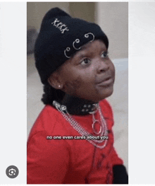 a young girl wearing a black beanie and a red shirt says no one even cares about you