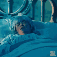 a woman is screaming in a bed with a snl logo in the corner