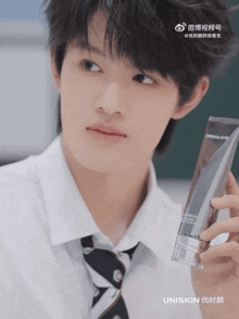 a young man in a white shirt and tie is holding a uniskin product in his hand