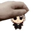 a hand is holding a small cartoon character on top of a person 's head .