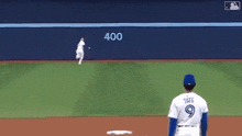 a baseball player is holding his glove up in the air while another player looks on .